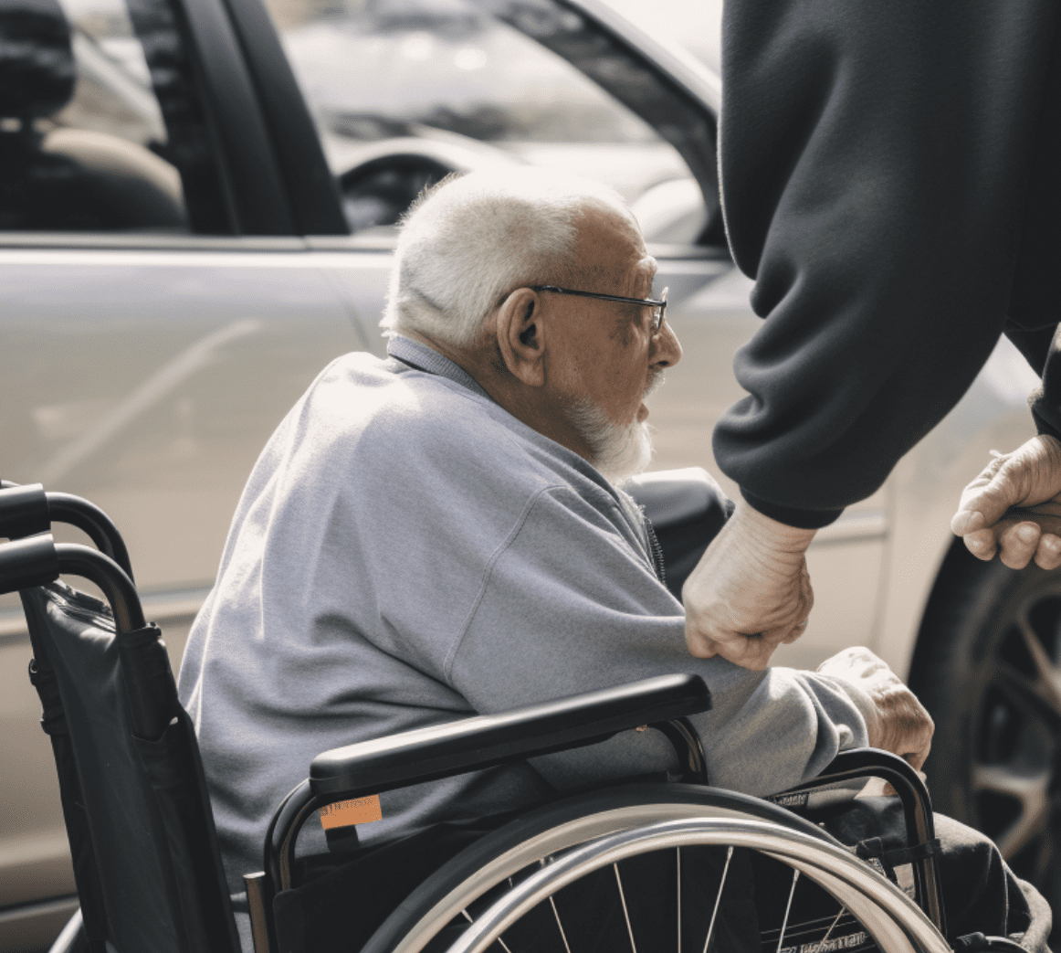 Una persona en silla de ruedas ayudada por alguien