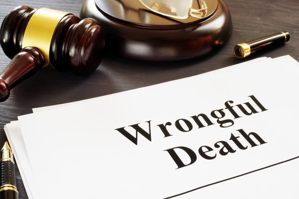 A legal document titled &ldquo;Wrongful Death&rdquo; on a desk with a judge&rsquo;s gavel, pen, and glasses, symbolizing a wrongful death lawsuit.