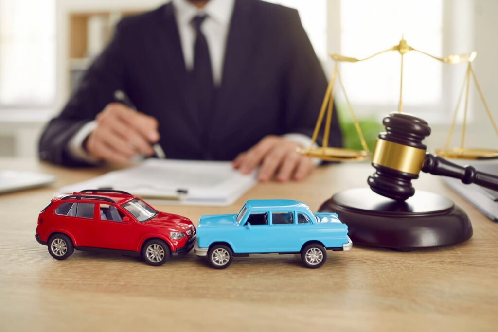 How a DFW Car Accident Lawyer Can Help With Insurance Claims and Compensation DFW car accident lawyer reviewing a crash claim with model cars and legal gavel representing legal help after a Dallas Fort Worth car accident