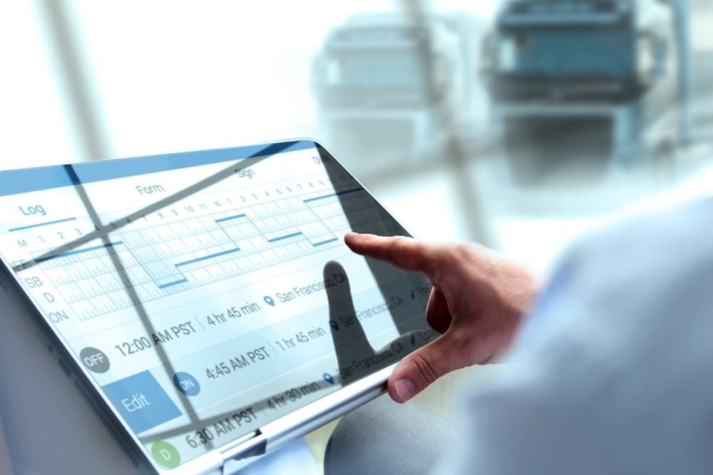 Hand reviewing electronic logging device data that shows truck driver hours and activity, used as black box evidence after a truck accident.