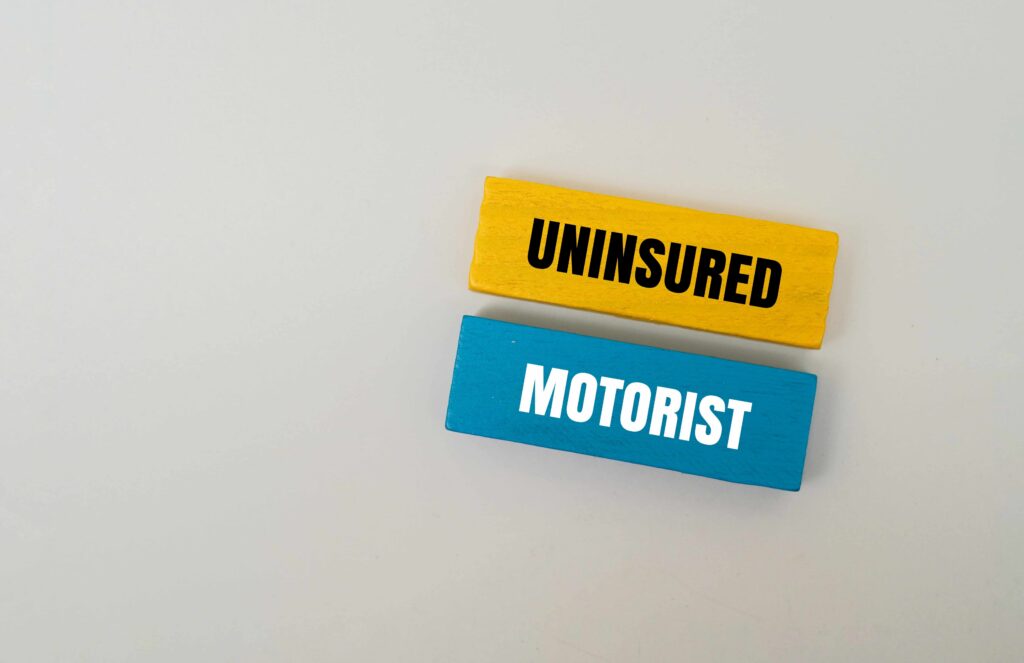 Uninsured motorist coverage concept with wooden blocks labeled &lsquo;Uninsured Motorist,&rsquo; representing protection after an accident with an uninsured driver.