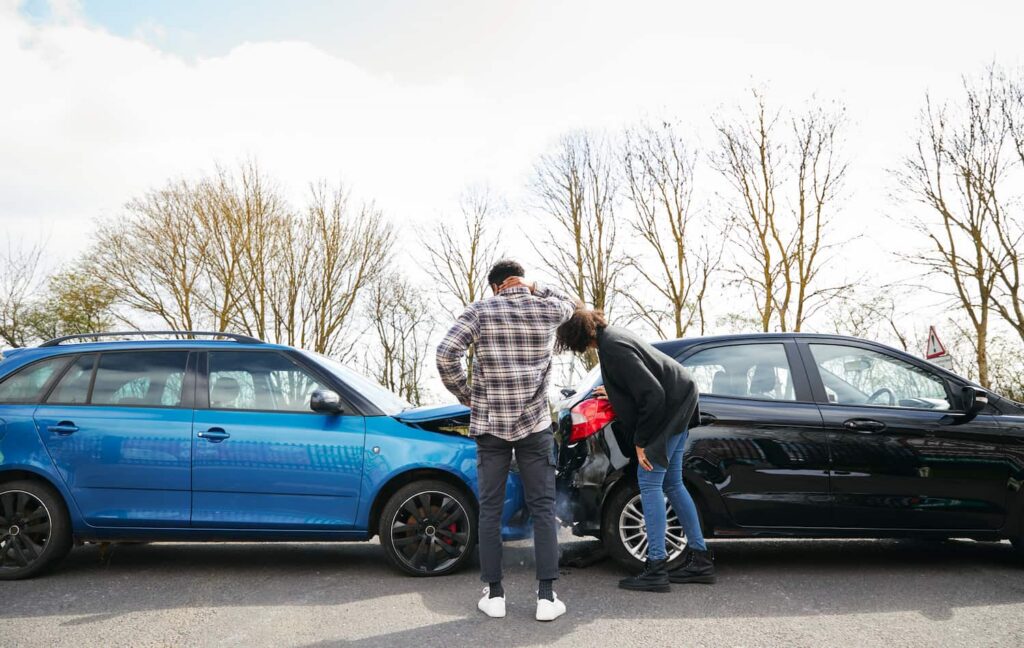 Gathering Evidence After a Car Accident for Injury Claim Drivers inspecting vehicle damage after a car accident while gathering evidence for a personal injury claim