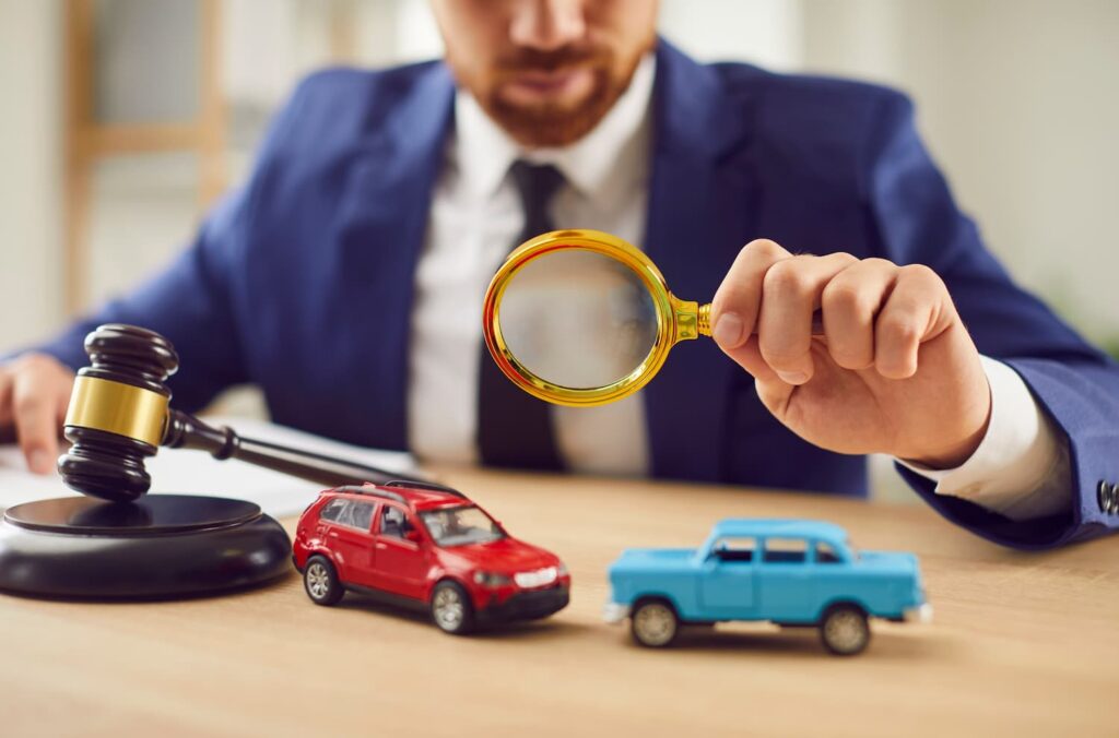 Car accident lawyer reviewing crash evidence with model vehicles and gavel to determine fault in a Dallas car accident claim