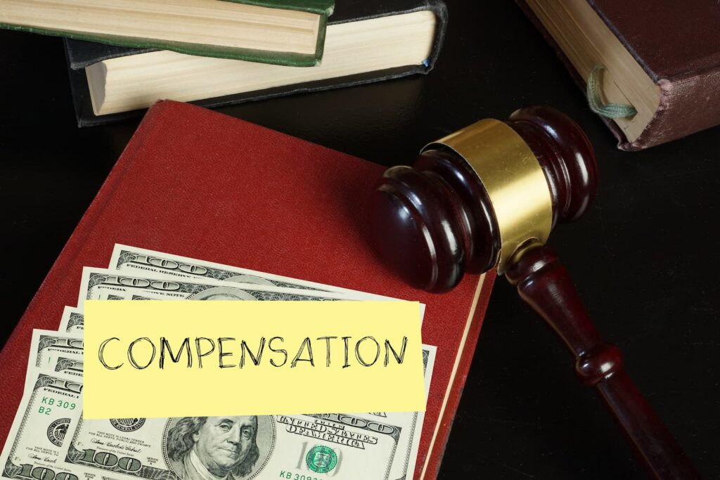 Personal injury compensation concept with judge gavel, law books, and US dollar bills representing legal settlement