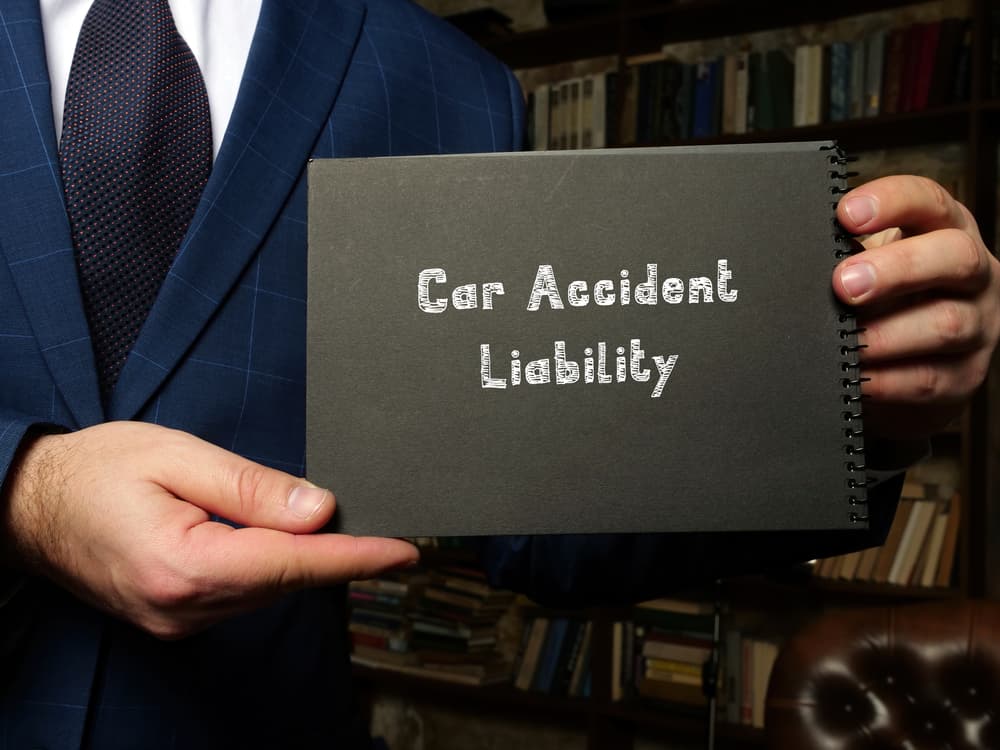 Understanding Liability and Comparative Fault in a Texas Car Accident Claim Car accident liability concept with attorney holding notebook explaining fault and proportionate responsibility in a Texas car accident claim