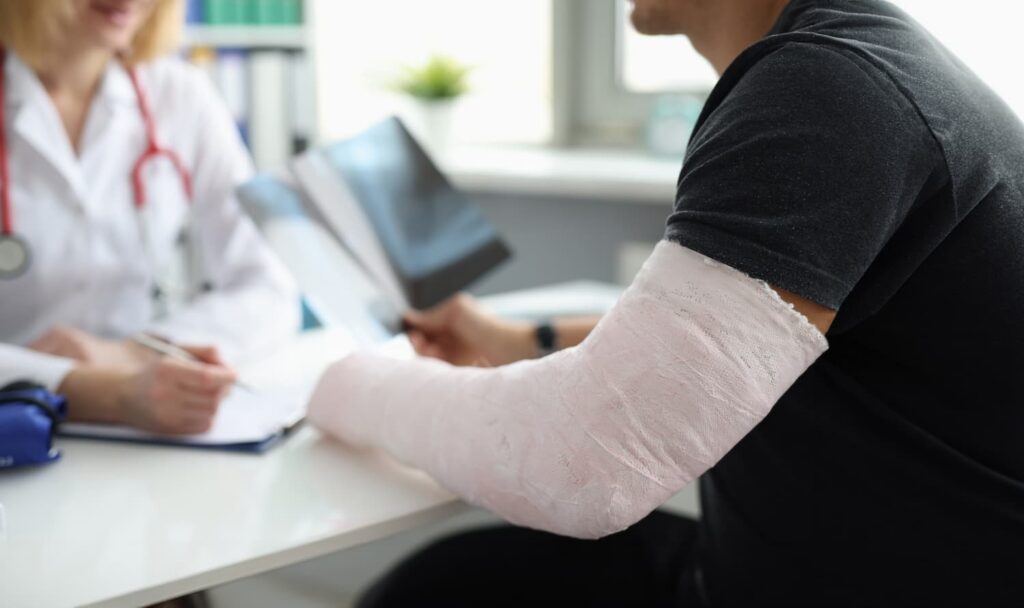 Defense Medical Exam in Arlington for Injury Claim Evaluation Arlington defense medical exam consultation with injured patient wearing arm cast during insurance evaluation