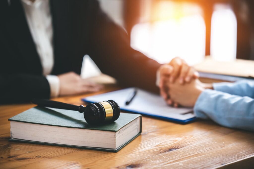 Arlington Wrongful Death Lawyer Consultation for Fatal Accident Compensation Arlington wrongful death lawyer consultation with client, gavel on law book representing fatal accident compensation claim