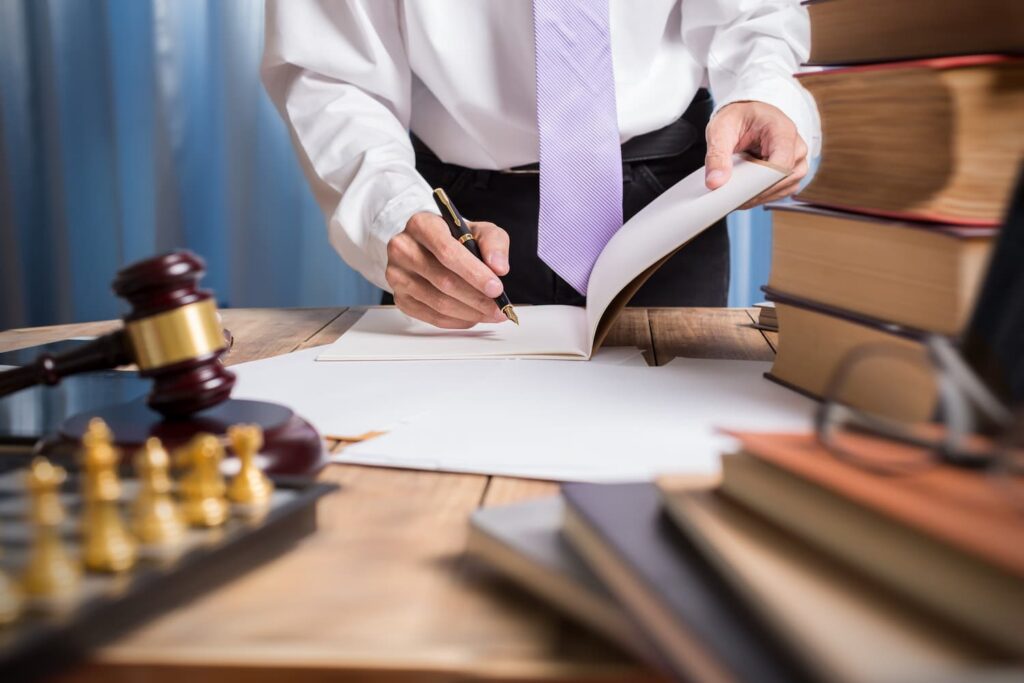 Dallas personal injury lawyer reviewing legal documents and preparing a car accident claim case with law books and gavel on desk.