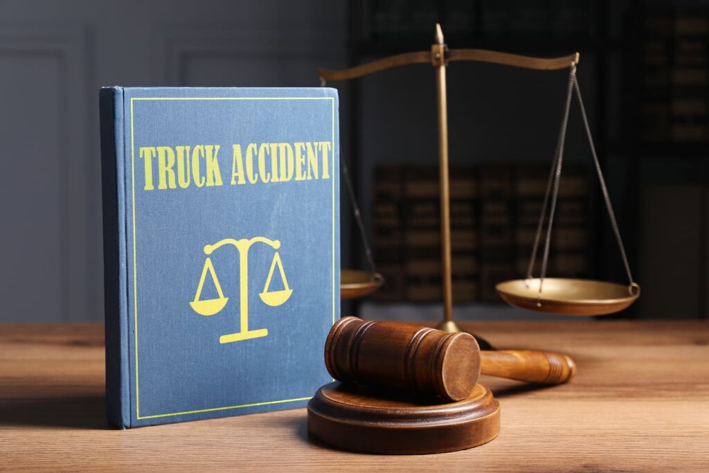 Why You Need An Oak Cliff Truck Accident Lawyer To Fight Trucking Companies Truck accident law book with gavel and scales of justice representing legal claims and compensation
