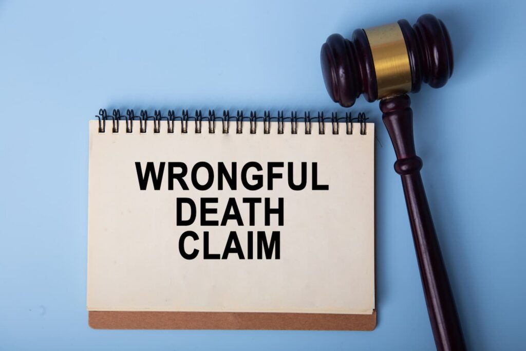 Wrongful death claim concept with judge gavel and legal notebook on blue background