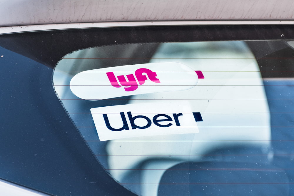 Adhesivos de los servicios de transporte compartido Uber y Lyft colocados en la luneta trasera de un vehículo.