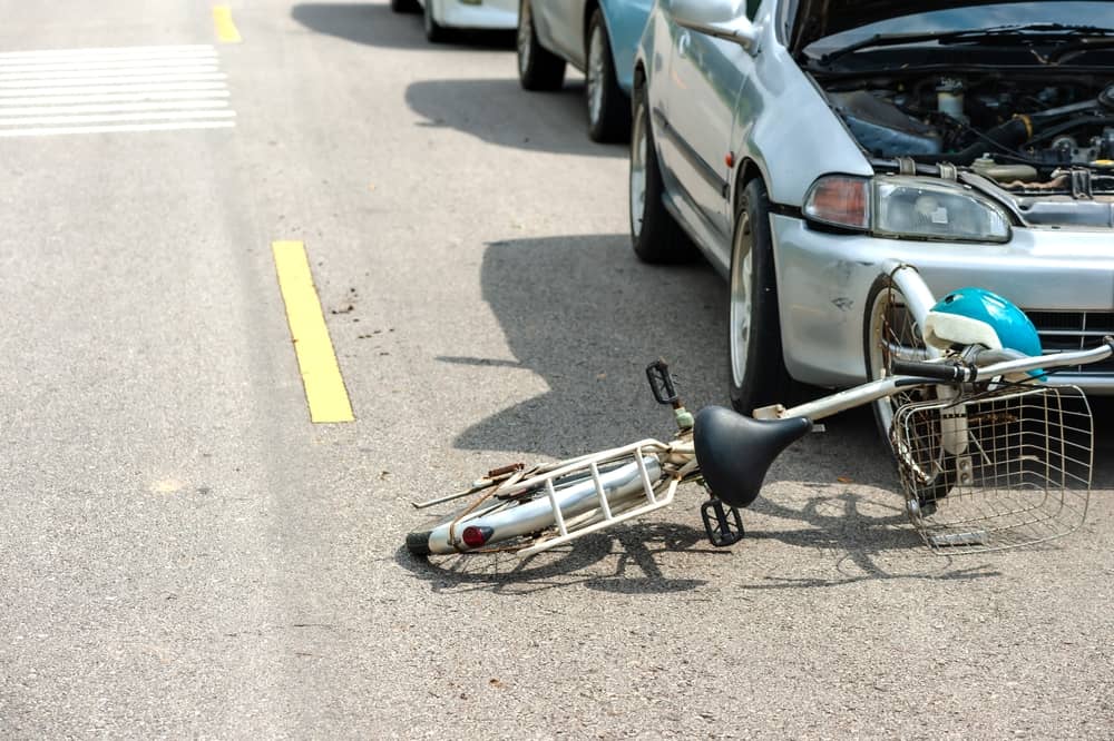 Bicicleta tirada en la calzada tras chocar con un turismo implicado en un accidente de tráfico.