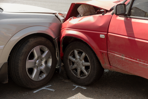 head-on collision of two cars, a silver and a red.