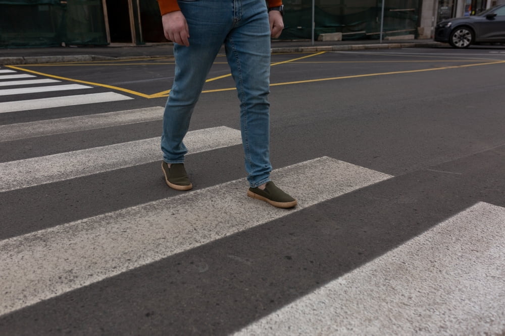 Peatón que cruza un paso de peatones señalizado en una calle de la ciudad