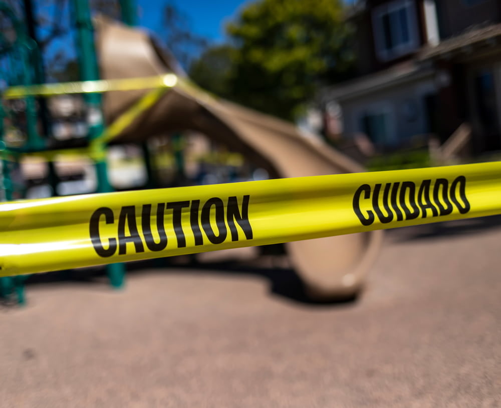 Caution tape blocking access to a playground after a hazardous condition, illustrating a potential premises liability claim.