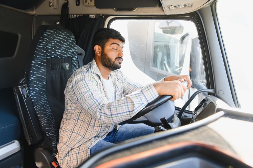 Fatigued truck driver appearing drowsy while operating a commercial truck