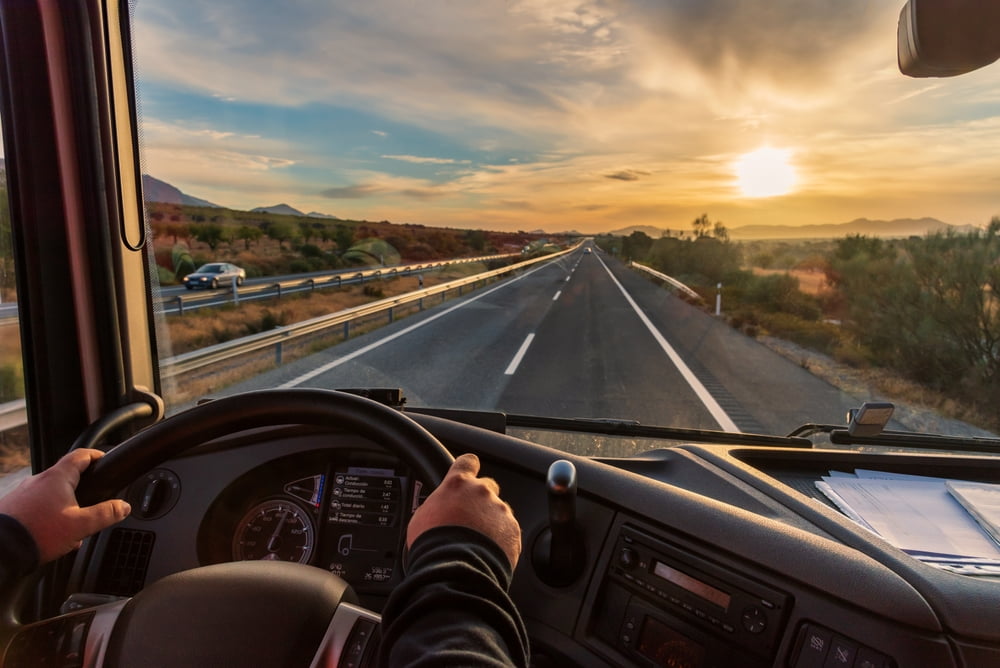 View from inside a commercial truck cab while driving on a highway